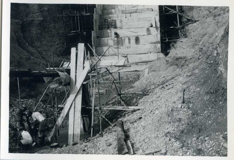 Scarico canale adduttore in costruzione. Operai e mezzi al lavoro